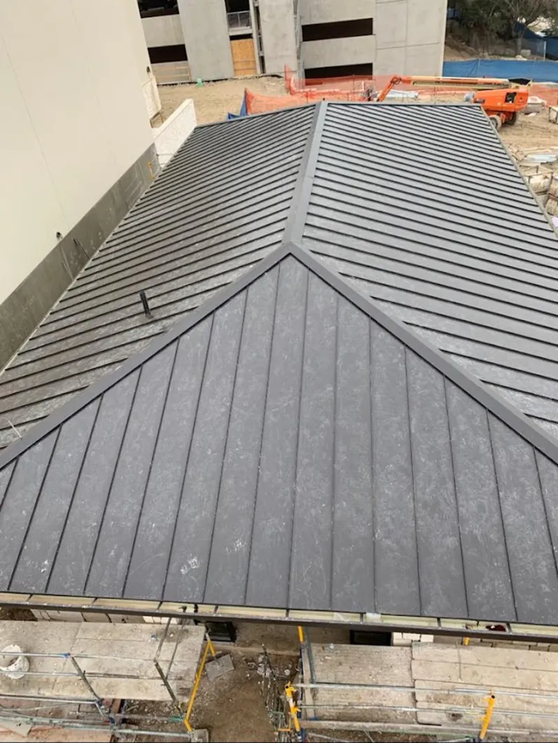 Commercial metal roof construction with crane equipment in Cottonwood Heights